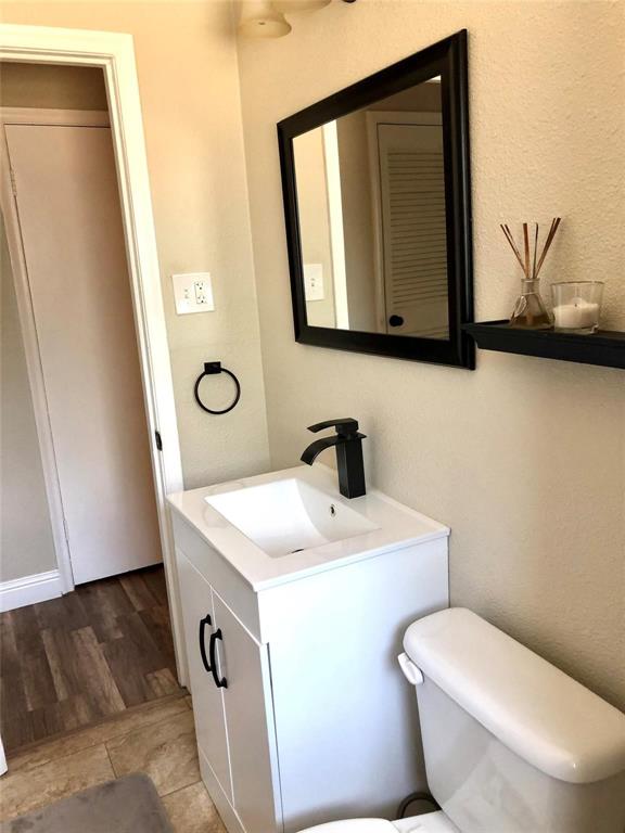 2127 East Mitchell Street Arlington, TX 76010 - Photo 14 of 20 a bathroom with a toilet a sink and mirror