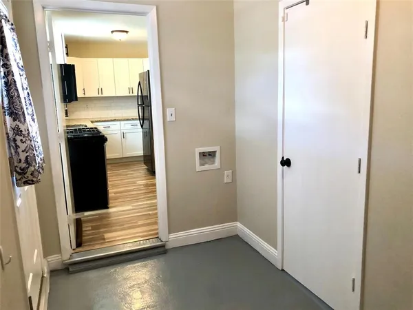 a view of a hallway with wooden floor and a bathroom