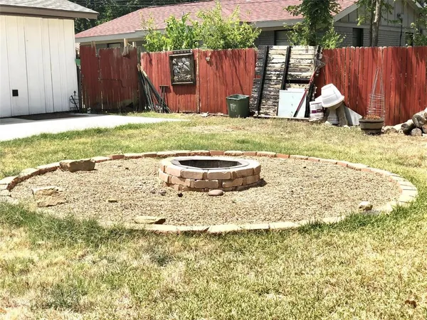 a view of a backyard with wooden fence