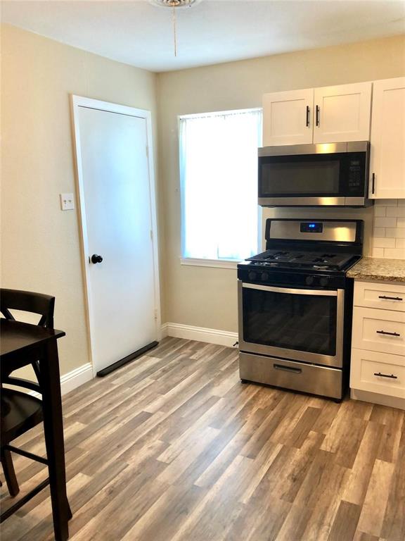 2127 East Mitchell Street Arlington, TX 76010 - Photo 4 of 20 a living room with a fireplace furniture a flat screen tv and a window