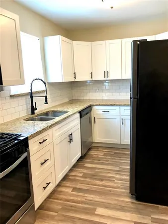 a kitchen with granite countertop white cabinets and appliances