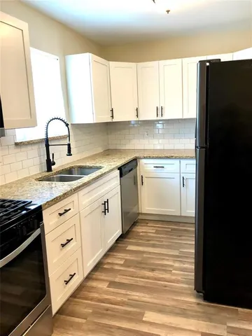 a kitchen with granite countertop white cabinets and appliances