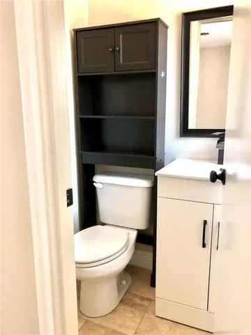a bathroom with a toilet a sink and mirror