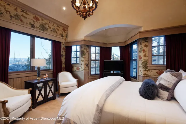 a living room with furniture a flat screen tv and a chandelier