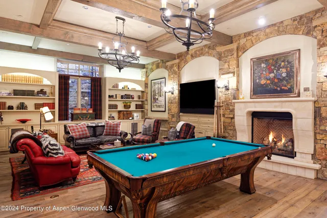a view of a dining room and livingroom with furniture wooden floor a chandelier