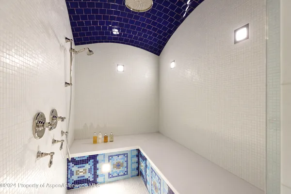 a bathroom with a granite countertop sink toilet a large mirror a shower and a bathtub