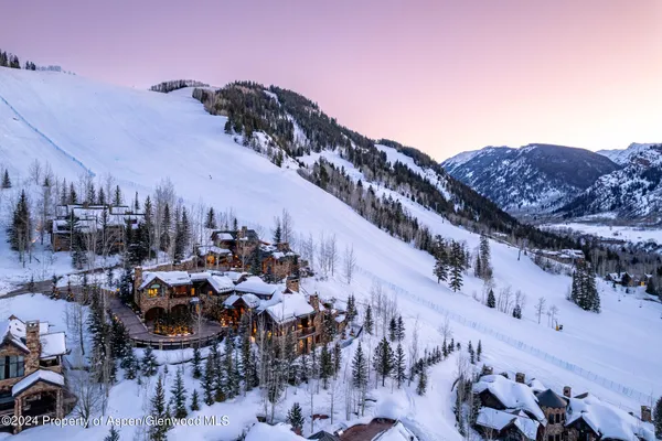a living room with patio furniture and a chandelier