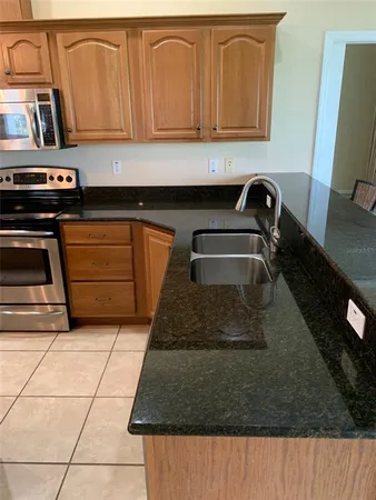 a kitchen with stainless steel appliances granite countertop a sink a stove and a refrigerator