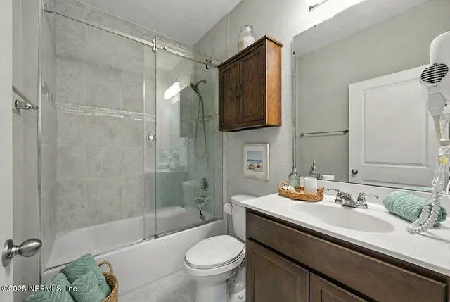 a bedroom with a bed and a flat tv screen on a dresser