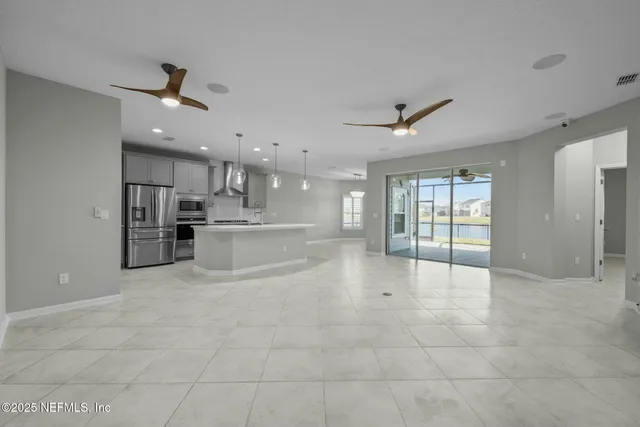 a large kitchen with stainless steel appliances granite countertop a sink a stove and a refrigerator