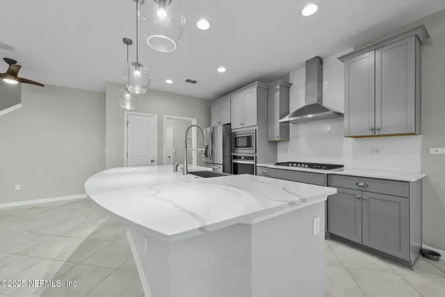 a kitchen with stainless steel appliances granite countertop a sink and a refrigerator