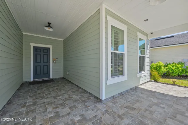 a living room with furniture potted plant and a large window