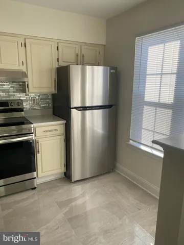 a white refrigerator freezer and a stove sitting inside of a kitchen