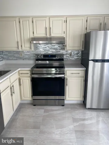 a kitchen with white cabinets and a stove top oven
