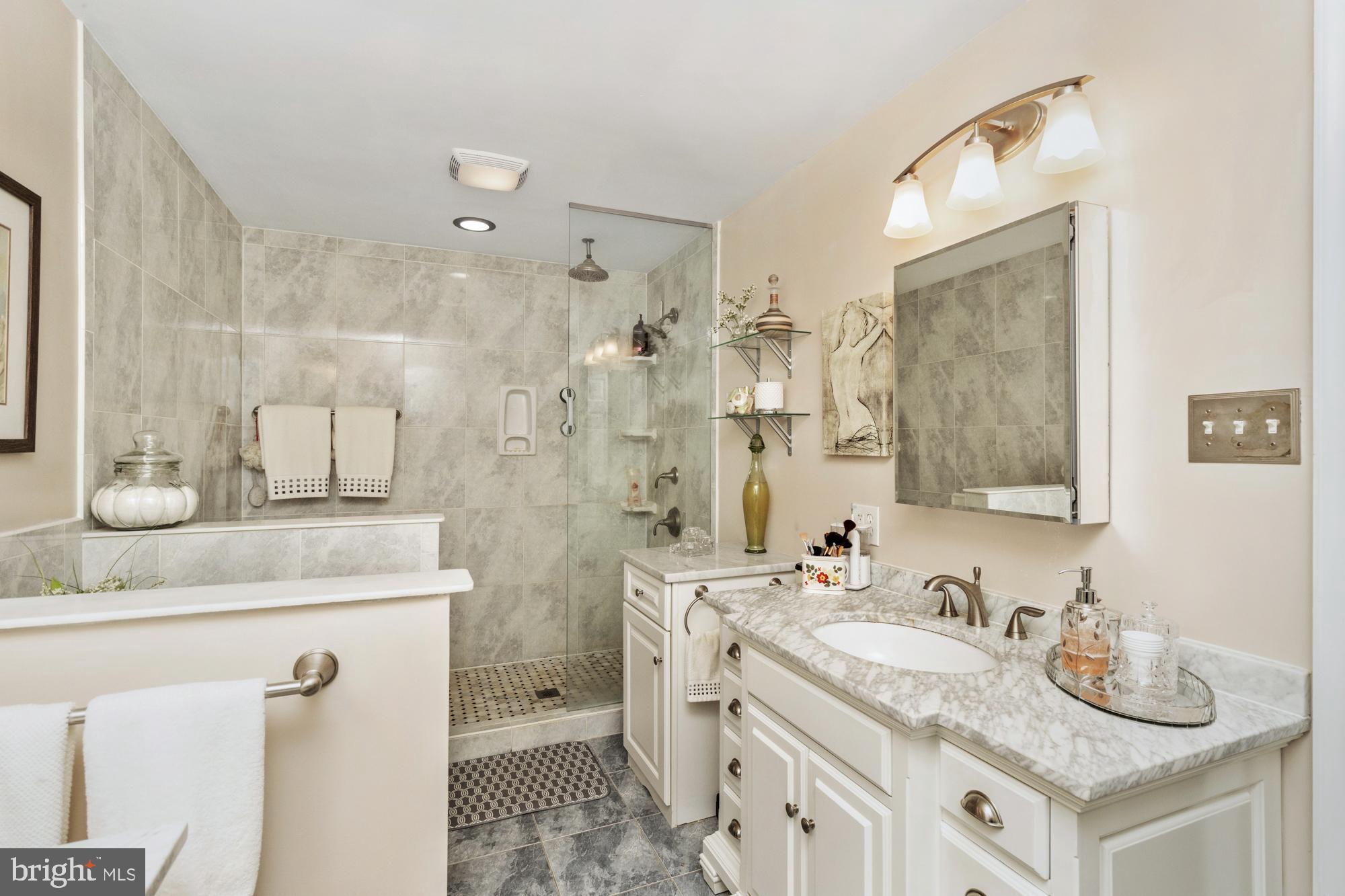 1002 Dunblane Road Towson, MD 21286 - Photo 36 of 59 a bathroom with a granite countertop double vanity sink mirror and shower
