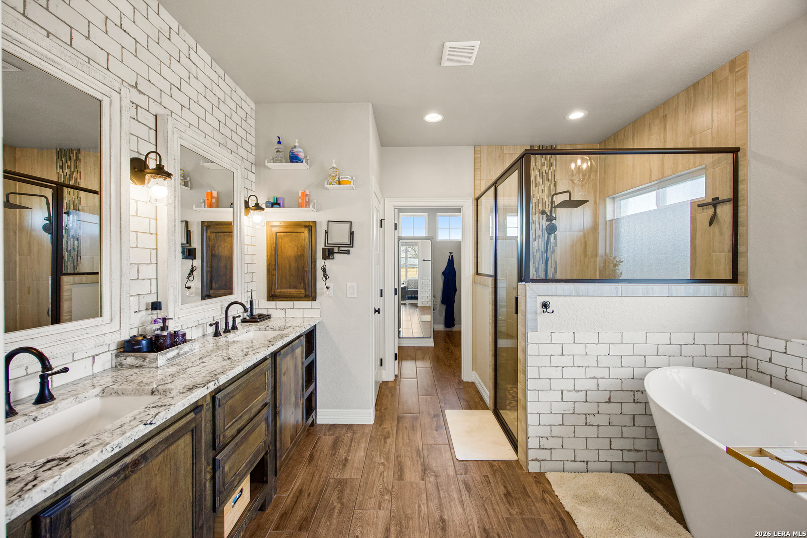121 Western Way Adkins, TX 78101 - Photo 26 of 46 a spacious bathroom with a granite countertop sink mirror and bathtub