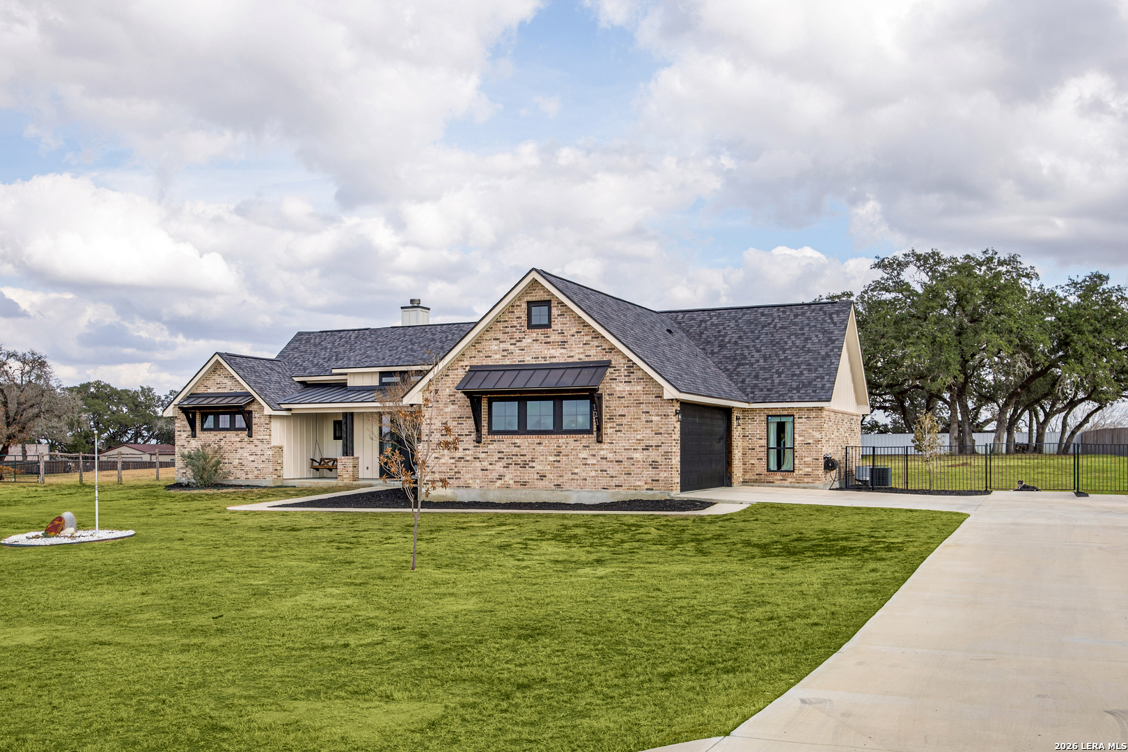121 Western Way Adkins, TX 78101 - Photo 5 of 46 a front view of a house with a garden and lake view