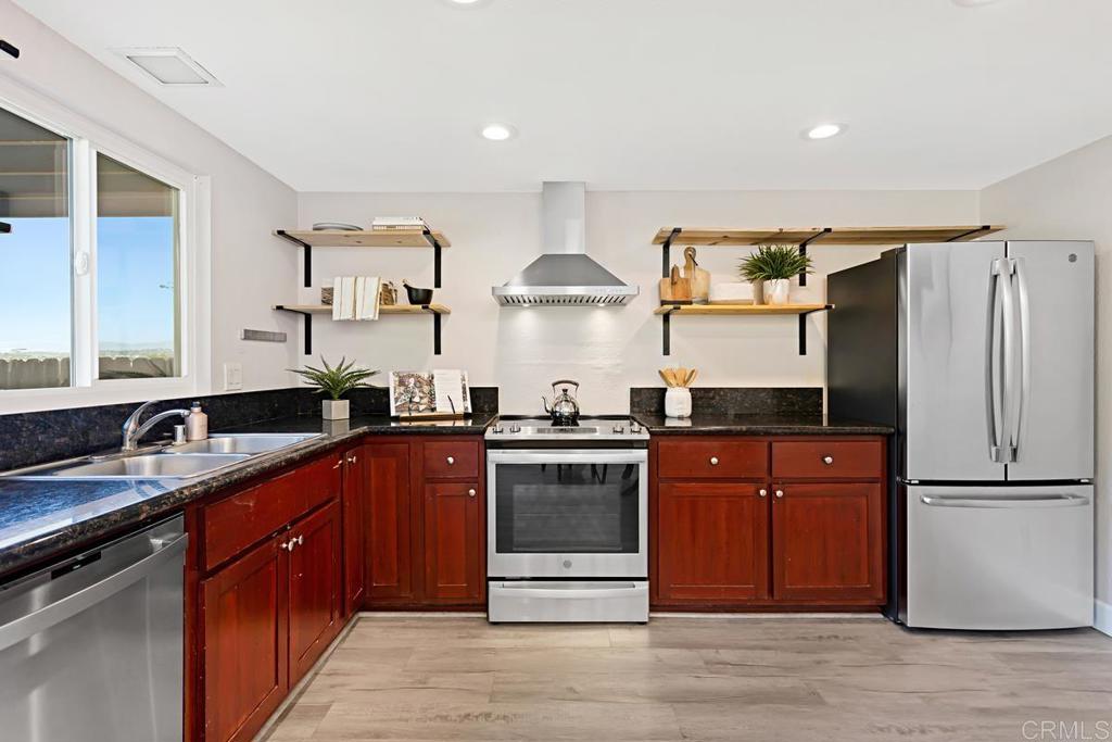 1081 Tylee Street Vista, CA 92083 - Photo 12 of 26 a kitchen with stainless steel appliances granite countertop a stove a sink dishwasher and a refrigerator