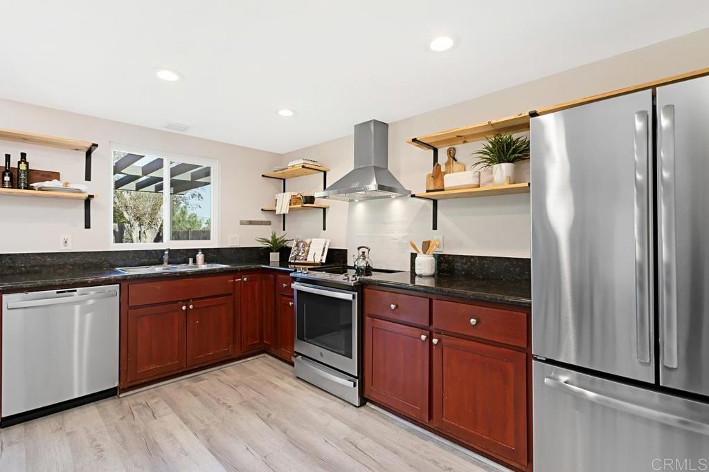 1081 Tylee Street Vista, CA 92083 - Photo 13 of 26 a kitchen with stainless steel appliances granite countertop a sink stove and refrigerator