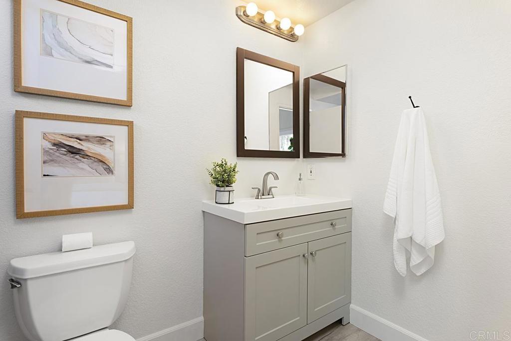 1081 Tylee Street Vista, CA 92083 - Photo 17 of 26 a bathroom with a toilet sink and mirror