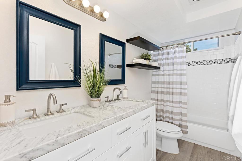 1081 Tylee Street Vista, CA 92083 - Photo 20 of 26 a bathroom with a granite countertop sink mirror vanity and toilet