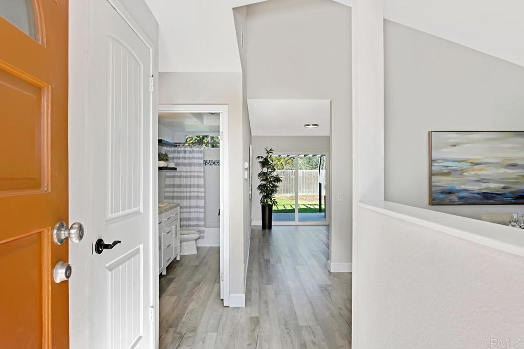 1081 Tylee Street Vista, CA 92083 - Photo 3 of 26 a view of a hallway with wooden floor and a living room