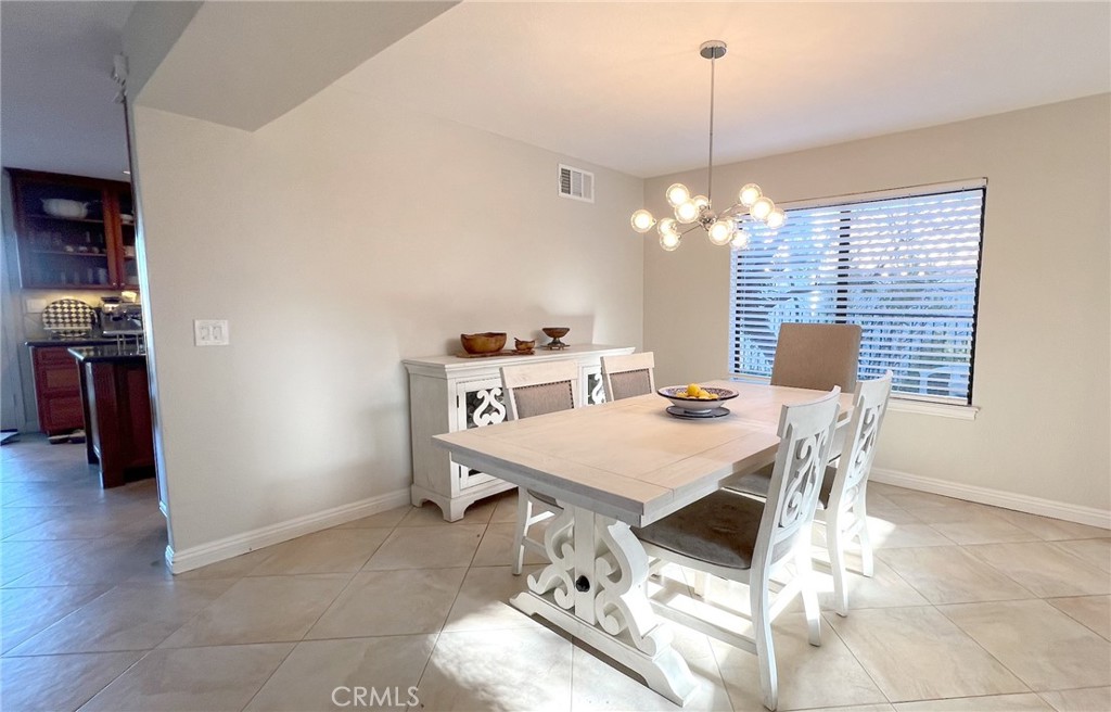 24394 Crestview Drive Newhall, CA 91321 - Photo 21 of 38 a dining room with a table chairs and chandelier