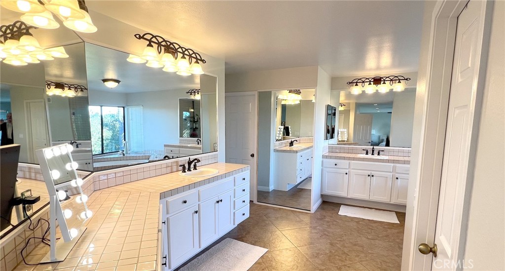 24394 Crestview Drive Newhall, CA 91321 - Photo 33 of 38 a large bathroom with a sink a large mirror and a shower