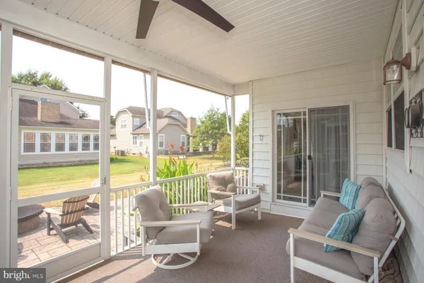 a living room with furniture and floor to ceiling windows