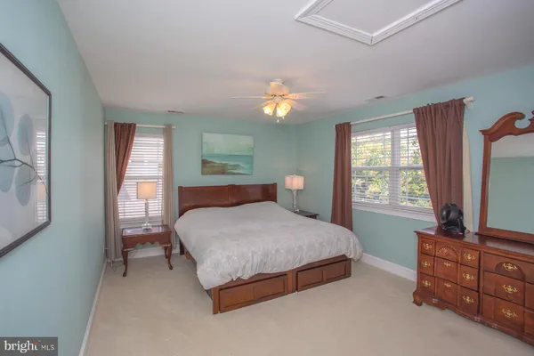 a bedroom with a bed and a dresser next to a window