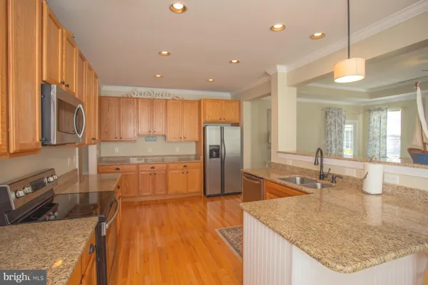 a kitchen with stainless steel appliances granite countertop a sink a stove and a refrigerator