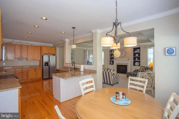 a kitchen with stainless steel appliances granite countertop a sink a stove a dining table and chairs