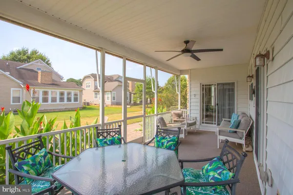 a view of a patio with couches table and chairs and potted plants