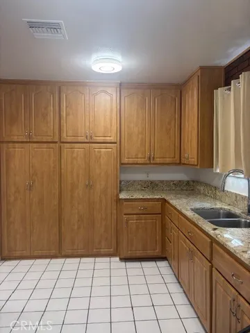 a kitchen with a sink a refrigerator and cabinets