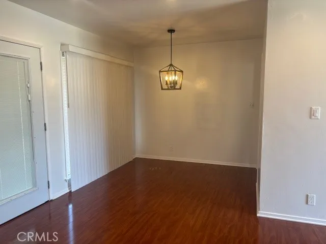 a view of a room with wooden floor and white walls