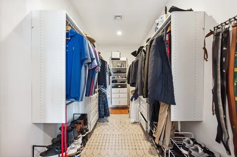 a view of walk in closet with clothes and shoes
