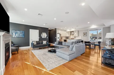 a living room with furniture kitchen view and a large window