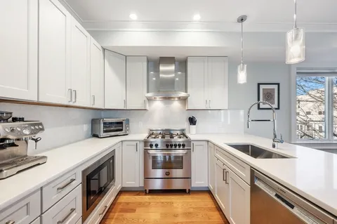 a kitchen with stainless steel appliances granite countertop a sink and a stove