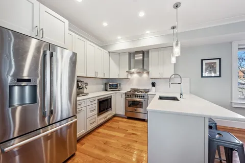 a kitchen with granite countertop a refrigerator stove and sink