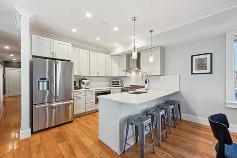a kitchen with refrigerator cabinets and wooden floor