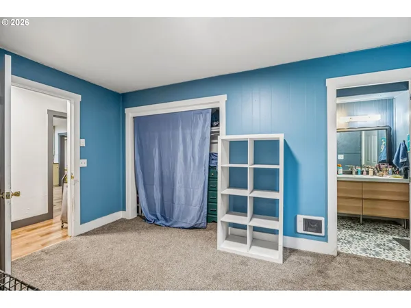 a view of an empty room with furniture and window
