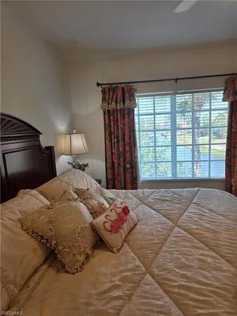 a bedroom with a large bed and a large window