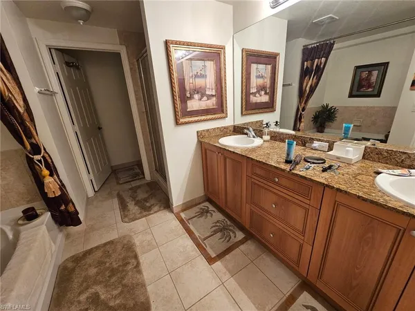 a spacious bathroom with a granite countertop sink a mirror and a shower