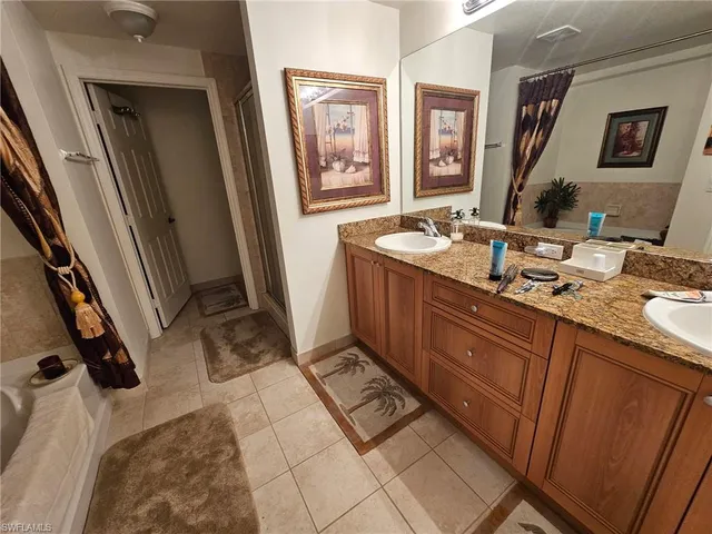 a spacious bathroom with a granite countertop sink a mirror and a shower