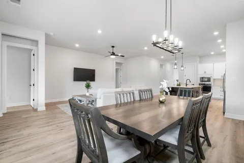 a view of a dining room with furniture a chandelier and wooden floor