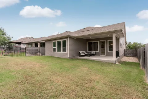 a view of a patio with table and chairs and floor to ceiling window