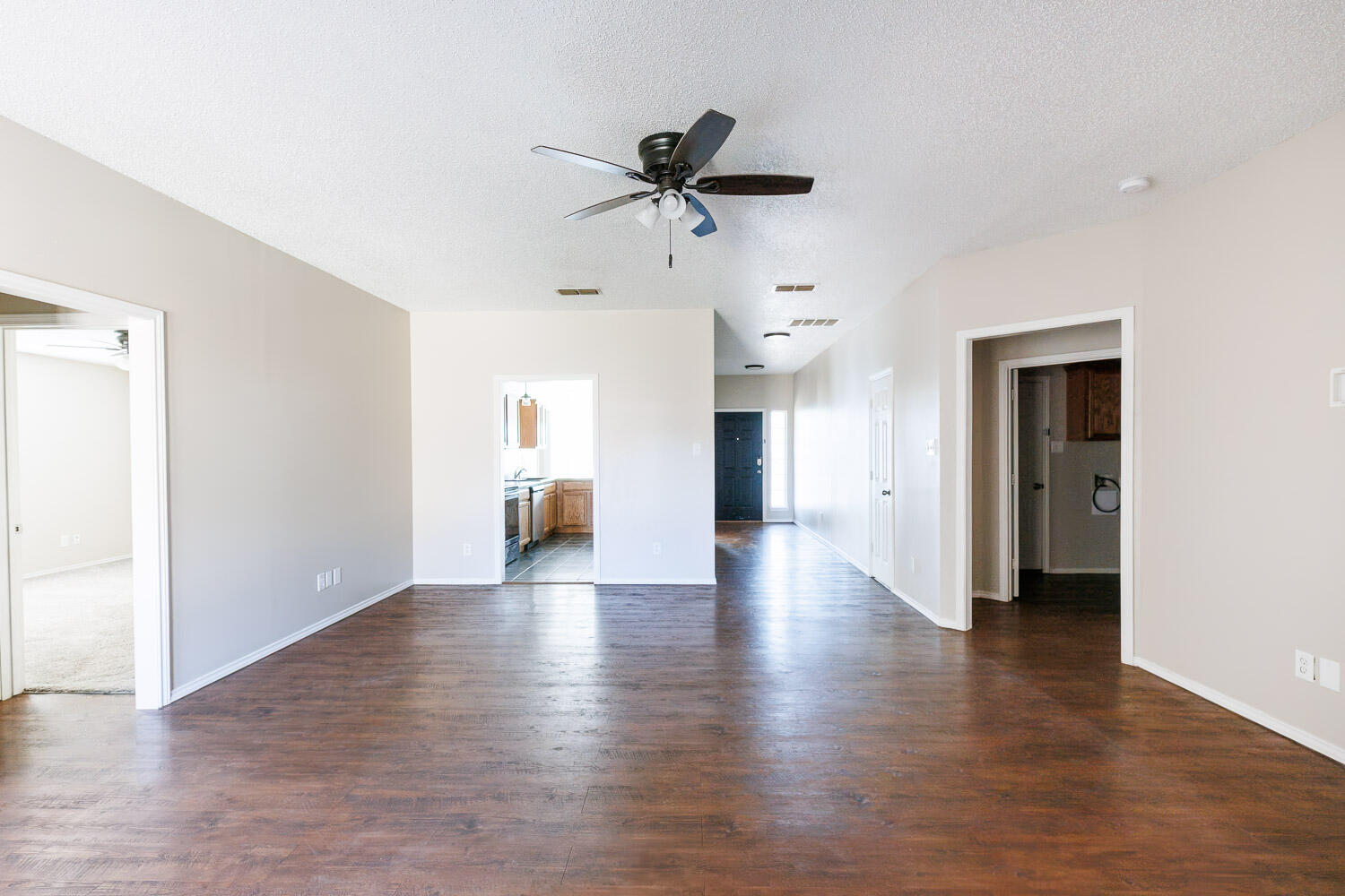 6704 87th Street Lubbock, TX 79424 - Photo 25 of 49 a view of a hallway with wooden floor and a ceiling fan