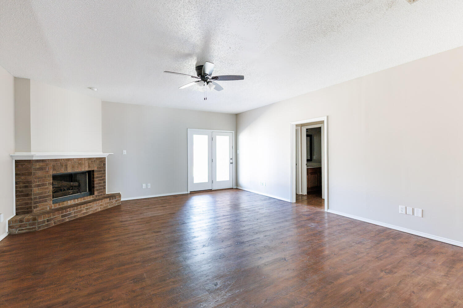 6704 87th Street Lubbock, TX 79424 - Photo 26 of 49 an empty room with wooden floor fireplace and windows