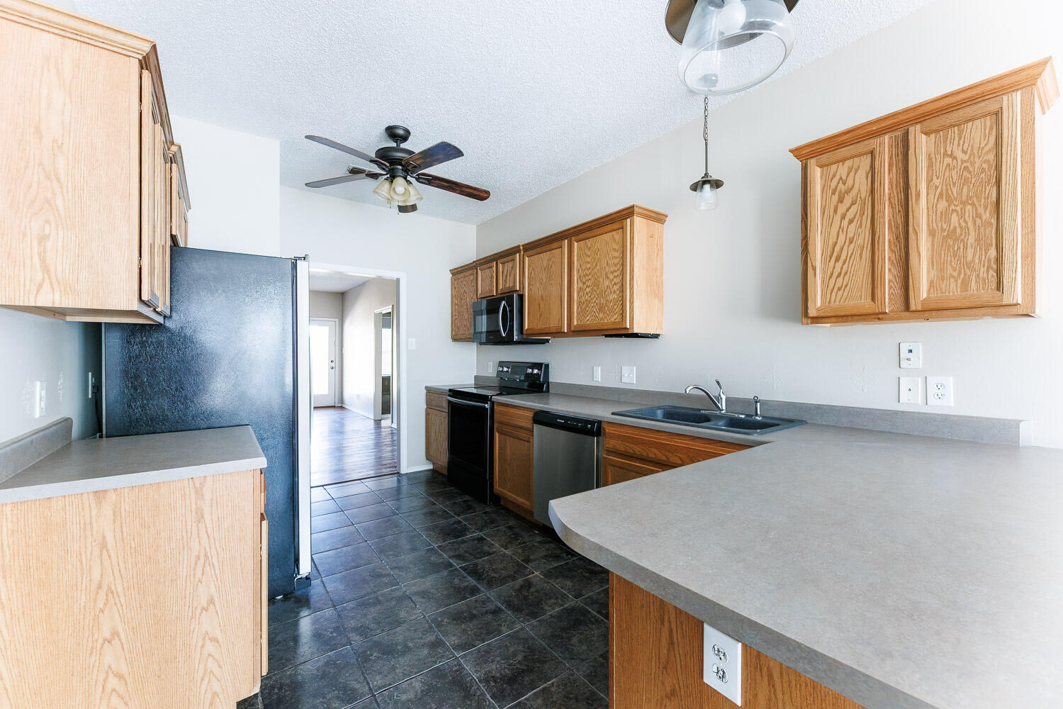 6704 87th Street Lubbock, TX 79424 - Photo 7 of 49 a kitchen with stainless steel appliances granite countertop a sink a stove top oven a chimney cabinets and a dining table