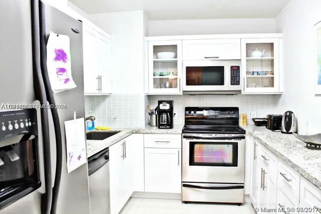 a kitchen with stainless steel appliances granite countertop a stove and a microwave